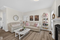 Spacious living area featuring light wood-finish flooring, a white trim package, and light-colored walls - 