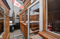 Private outdoor area featuring paver stone flooring and wood-paneled walls - 