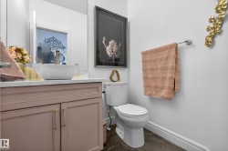 Powder room featuring a vessel sink, white countertop, and a vanity with pink cabinetry - 