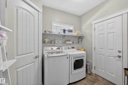 Dedicated laundry area featuring a window, built-in shelving, and wood-finish flooring - 