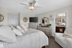 Carpeted bedroom with a ceiling fan, recessed lighting, and a white paneled door - 