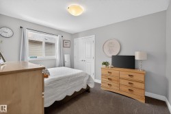 Bedroom featuring light gray wall paint and dark carpet flooring - 