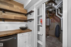 Wet bar featuring wood paneling, open shelving with pipe supports, a vessel sink, and a live-edge wood countertop - 