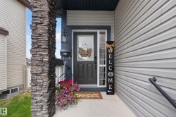 Front entry featuring a stacked stone pillar, concrete porch, and horizontal siding - 