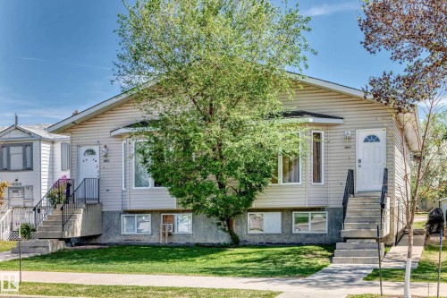 Duplex property featuring light-colored horizontal siding and a prominent bay window - 10017 153 Street, Edmonton, AB - Outdoor With Facade