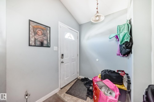 Entryway featuring a white paneled door with an arched glass insert, light gray walls, and a ceiling-mounted pendant light fixture - 10017 153 Street, Edmonton, AB - Indoor Photo Showing Other Room