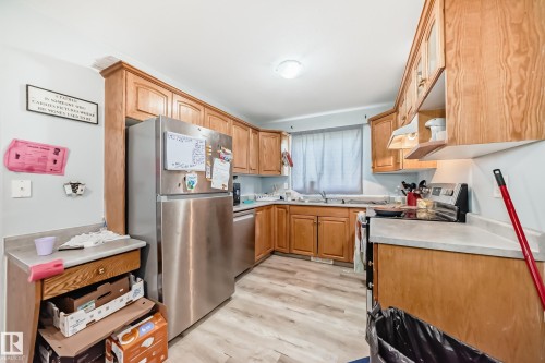 Kitchen featuring wood cabinetry, light-toned countertops, and wood-finish flooring - 10017 153 Street, Edmonton, AB - Indoor Photo Showing Kitchen