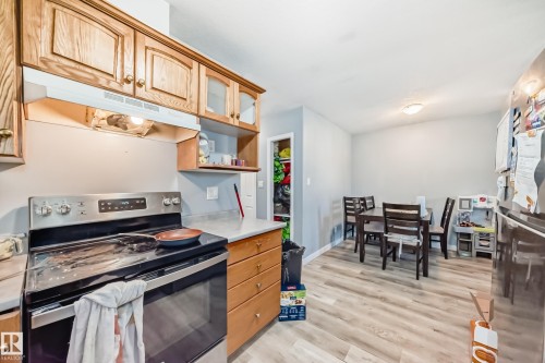 Kitchen featuring wood cabinetry, stainless steel range, and light-toned countertops - 10017 153 Street, Edmonton, AB - Indoor Photo Showing Kitchen