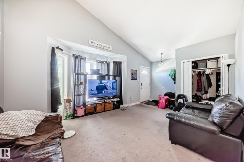 Living area featuring a vaulted ceiling and light gray wall paint - 10017 153 Street, Edmonton, AB - Indoor