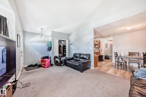 Living area featuring carpeting, vaulted ceiling, and an entry door - 10017 153 Street, Edmonton, AB - Indoor