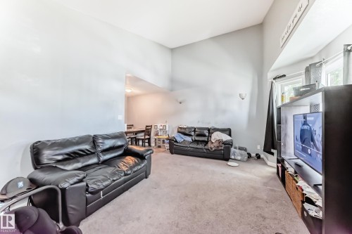 Living area featuring vaulted ceilings, light gray wall paint, and a carpeted floor - 10017 153 Street, Edmonton, AB - Indoor