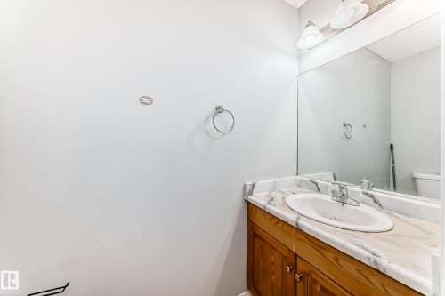 Wood-finish vanity with an integrated basin, featuring a patterned countertop - 10017 153 Street, Edmonton, AB - Indoor Photo Showing Bathroom