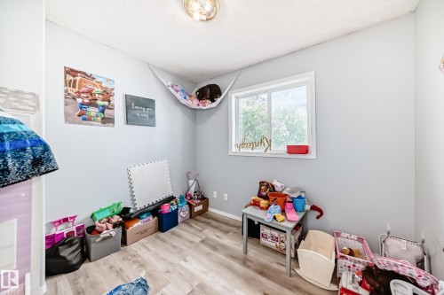 Room featuring light wood-finish flooring and a single window with white trim - 10017 153 Street, Edmonton, AB - Indoor
