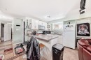 Kitchen featuring white cabinetry with brushed nickel hardware, laminate countertops, a tile backsplash, and ceramic tile flooring - 10017 153 Street, Edmonton, AB  - Indoor Photo Showing Kitchen 