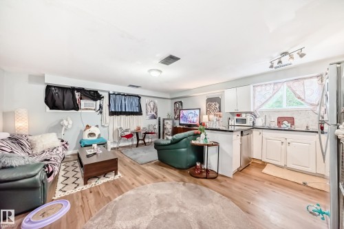 Open-concept living space featuring wood-finish flooring, recessed lighting, and a neutral wall color - 10017 153 Street, Edmonton, AB - Indoor