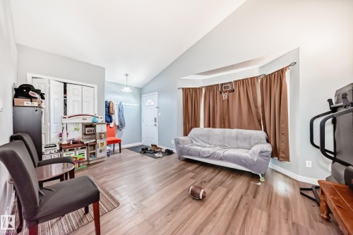 Spacious interior featuring wood-finish flooring, a vaulted ceiling, and a bay window - 10017 153 Street, Edmonton, AB - Indoor