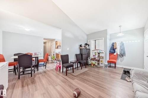 Open-concept living area with wood-finish flooring, light grey wall paint, and white trim - 10017 153 Street, Edmonton, AB - Indoor