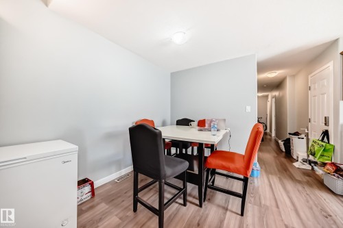 Dining area featuring wood-finish flooring, a contemporary overhead light fixture, and light-colored walls - 10017 153 Street, Edmonton, AB - Indoor Photo Showing Dining Room