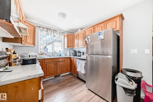 Kitchen featuring wood-finish cabinetry, light-toned countertops, and wood-finish flooring - 10017 153 Street, Edmonton, AB - Indoor Photo Showing Kitchen