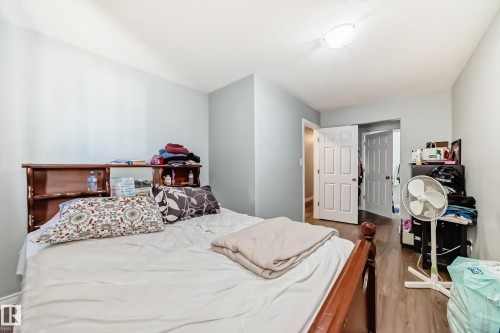 Bedroom featuring wood-finish flooring, light blue wall paint, and white trim - 10017 153 Street, Edmonton, AB - Indoor Photo Showing Bedroom