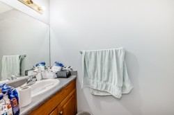 Bathroom vanity featuring a built-in sink, laminate countertop, wood-finish cabinetry, and mosaic tile backsplash - 
