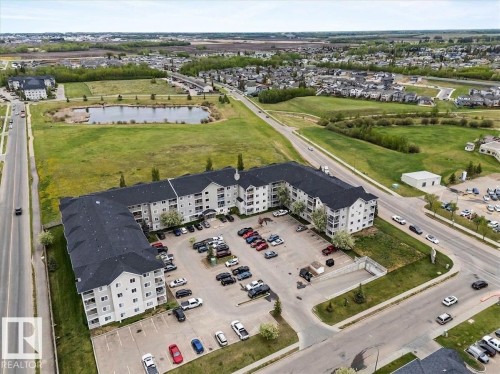 Modern multi-story residential building featuring a dark shingle roof and light-colored siding - 115 4309 33 Street, Stony Plain, AB 