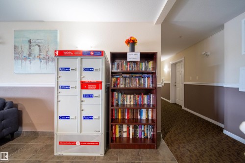 Hallway featuring a built-in mail center and a communal bookshelf - 115 4309 33 Street, Stony Plain, AB 