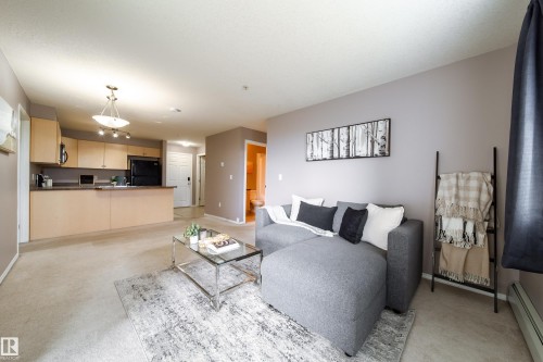 Open-concept living space featuring light-toned carpeting and a neutral wall color - 115 4309 33 Street, Stony Plain, AB 