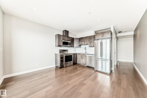 Kitchen featuring stainless steel appliances, wood-finish flooring, recessed lighting, shaker-style cabinetry, and a white tile backsplash - 2604 10238 103 Street, Edmonton, AB 