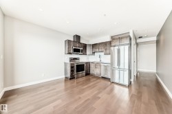 Kitchen featuring stainless steel appliances, wood-finish flooring, recessed lighting, shaker-style cabinetry, and a white tile backsplash - 