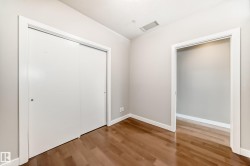 Interior room featuring wood-finish flooring, light neutral wall paint, and white baseboards - 