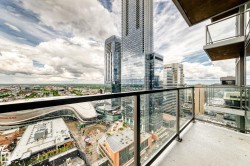 Balcony with glass railing and textured flooring, offering urban panorama and architectural features including modern skyscrapers - 