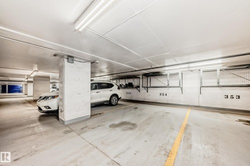 Underground parking garage featuring concrete flooring, overhead fluorescent lighting, and numbered parking stalls - 2604 10238 103 Street, Edmonton, AB 