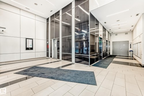 Building lobby featuring light-toned tile flooring with dark accent stripes - 2604 10238 103 Street, Edmonton, AB 