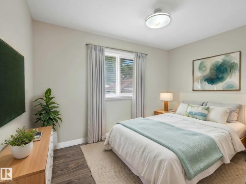 Bedroom featuring wood-finish flooring, a contemporary ceiling light fixture, and a window with blinds - 12241 54 Street, Edmonton, AB 
