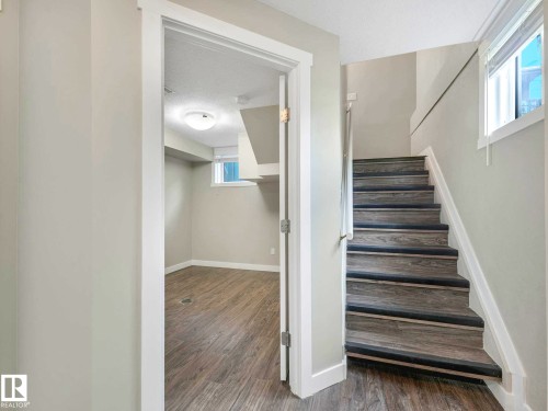 Wood-finish stairs with dark tread accents - 12241 54 Street, Edmonton, AB 