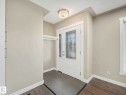Entryway featuring a white door with decorative leaded glass, tile flooring, and a built-in coat rack - 12241 54 Street, Edmonton, AB 