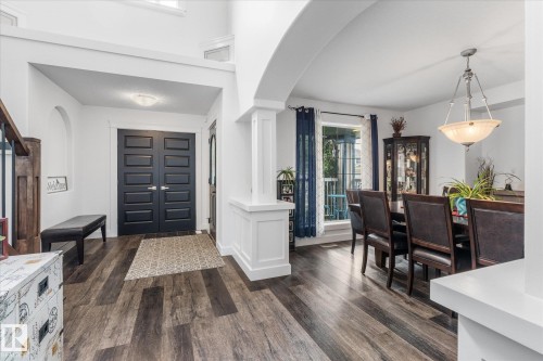 Entryway featuring dark double doors, wood-finish flooring, white trim, and a recessed archway - 18 Woodbend Way, Fort Saskatchewan, AB 