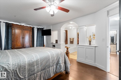 Bedroom featuring wood-finish flooring, a ceiling fan with integrated lighting, and white walls - 18 Woodbend Way, Fort Saskatchewan, AB 