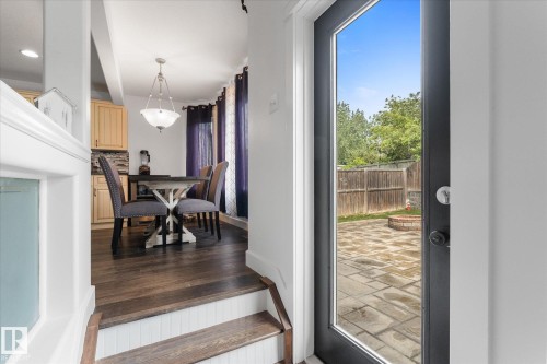 Hardwood-finish flooring extending into the dining area with a decorative chandelier - 18 Woodbend Way, Fort Saskatchewan, AB 