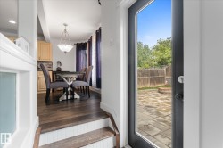 Hardwood-finish flooring extending into the dining area with a decorative chandelier - 