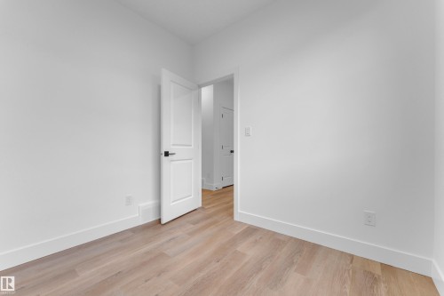 Room featuring light wood-finish flooring, white walls, and white baseboards - 4213 63 Street, Beaumont, AB 