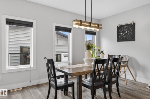 Dining area featuring wood-finish flooring, light gray wall paint, and white trim - 17733 64A Street, Edmonton, AB 