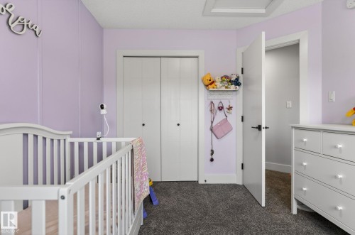 Room featuring a soft purple wall color, white trim, and dark gray carpeting - 17733 64A Street, Edmonton, AB 