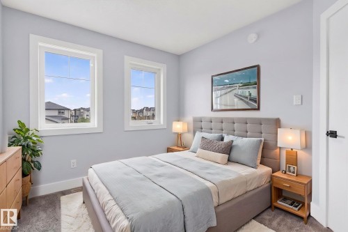 Bedroom featuring two large windows with white trim, light gray walls, and a tufted fabric headboard - 17733 64A Street, Edmonton, AB 