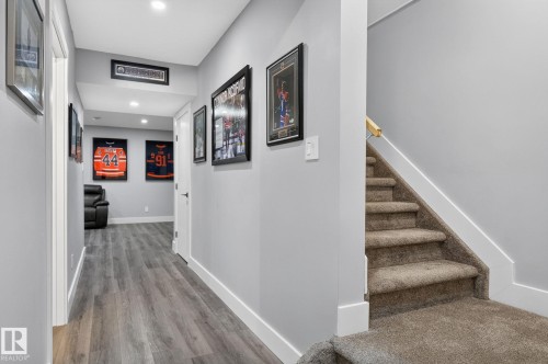Hallway featuring wood-finish flooring, recessed lighting, and a neutral color palette - 17733 64A Street, Edmonton, AB 
