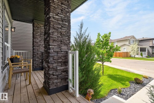 Front porch featuring stacked stone columns, wood-finish flooring, and white railing accents - 17733 64A Street, Edmonton, AB 