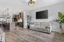 Open-concept living area featuring wood-finish flooring, recessed lighting, and a neutral color palette - 17733 64A Street, Edmonton, AB 