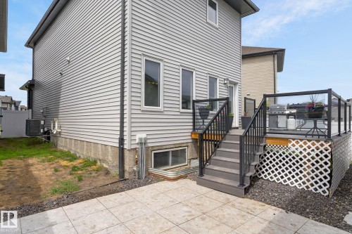 Spacious rear deck with dark composite decking, black metal railings, and clear glass panels - 17733 64A Street, Edmonton, AB 