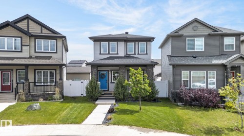 Two-story residence featuring light gray siding, dark trim, and a stone accent column at the entry - 17733 64A Street, Edmonton, AB 